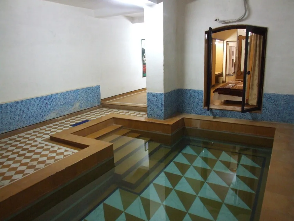 Cottage Deluxe interior with a king-sized bed, warm lighting and private indoor pool access