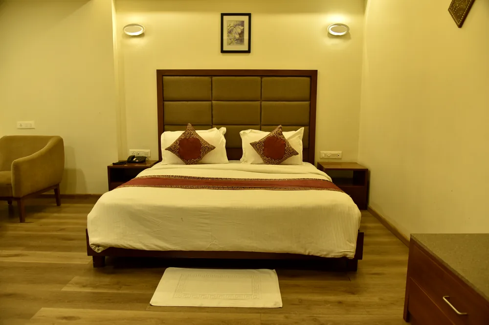 Premium Deluxe room with plush bedding and an en-suite bathroom with rain shower